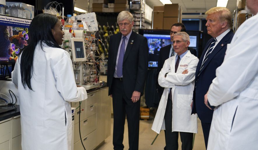 FILE - In this Tuesday, March 3, 2020 file photo, Dr. Kizzmekia Corbett, left, senior research fellow and scientific lead for coronavirus vaccines and immunopathogenesis team in the Viral Pathogenesis Laboratory, talks with President Donald Trump as he tours the Viral Pathogenesis Laboratory at the National Institutes of Health in Bethesda, Md. Dozens of research groups around the world are racing to create a vaccine as COVID-19 cases continue to grow. (AP Photo/Evan Vucci)