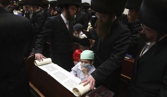 CORRECTS SPELLING OF PURIM - Ultra Orthodox Jewish boy wears a doctor&#39;s costume during the first day of a Purim holiday as the Book of Esther is read in a synagogue in Bnei Brak, Israel, Monday, March 9, 2020. (AP Photo/Oded Balilty)