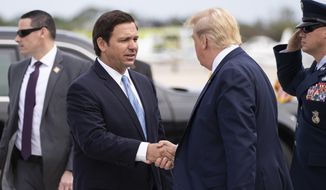 Gov. Ron DeSantis, R-Fla., greets President Donald Trump as he steps off Air Force One upon arrival at the Orlando Sanford International Airport, Monday, March 9, 2020, in Orlando, Fla. (AP Photo/Alex Brandon) ** FILE **