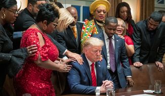 African American leaders say a prayer with President Donald Trump as they end a meeting in the Cabinet Room of the White House, Thursday, Feb. 27, 2020, in Washington. (AP Photo/Manuel Balce Ceneta)