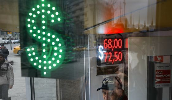 A man stands at an exchange office screen showing the currency exchange rates of U.S. Dollar and Euro to Russian Rubles in Moscow, Russia, Tuesday, March 10, 2020. Oil prices are plunging after Saudi Arabia started a price war against Russia. The Saudis tried to get the Russians to cut oil production to keep prices from falling even more due to the coronavirus. (AP Photo/Pavel Golovkin)