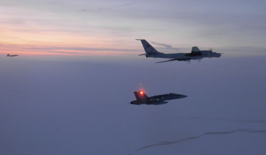 In this Monday, March 9, 2020, photo released by the North American Aerospace Defense Command (NORAD), a Russian Tu-142 maritime reconnaissance aircraft, top right, is intercepted near the Alaska coastline. U.S. and Canadian aircraft intercepted and escorted two Russian jets that flew over the Beaufort Sea near the Alaska coastline, military officials said Tuesday. The Russian Tu-142 maritime reconnaissance aircraft were escorted by F-22 and CF-18 planes, the North American Aerospace Defense Command said in a release. The Russian jets never left international airspace during the duration of the four-hour flight on Monday, but did come within 50 miles of the Alaska coast. (North American Aerospace Defense Command  via AP) ** FILE **