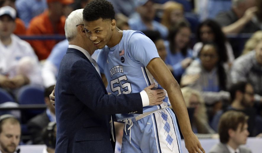 North Carolina head coach Roy Williams hugs North Carolina guard Christian Keeling (55) during the second half of an NCAA college basketball game against Virginia Tech at the Atlantic Coast Conference tournament in Greensboro, N.C., Tuesday, March 10, 2020. (AP Photo/Gerry Broome)