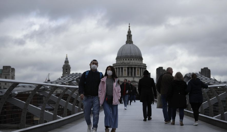 People wearing face masks walk across the Millennium footbridge backdropped by the dome of St Paul&#39;s Cathedral in London, Tuesday, March 10, 2020. Starkly illustrating the global east-to-west spread of the new coronavirus, Italy began an extraordinary, sweeping nationwide travel ban on Tuesday while in China, the diminishing threat prompted the president to visit the epicenter and declare: &amp;quot;&amp;quot;We will certainly defeat this epidemic.&amp;quot; (AP Photo/Matt Dunham)