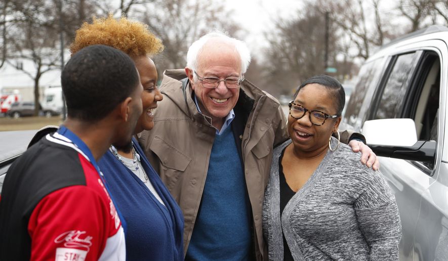Democratic presidential candidate Sen. Bernie Sanders, I-Vt., visits custodian Davonta Bynes, from left, principal DaRhonda Evans-Stewart and social worker Kim Little outside a polling location at Warren E. Bow Elementary School in Detroit, Tuesday, March 10, 2020. (AP Photo/Paul Sancya)
