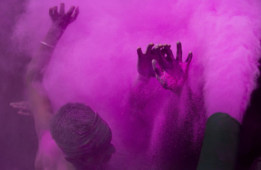 Indians dance and throw colored powder during Holi festival celebrations in Gauhati, India, Tuesday, March 10, 2020. The festival heralds the arrival of spring. (AP Photo/Anupam Nath)