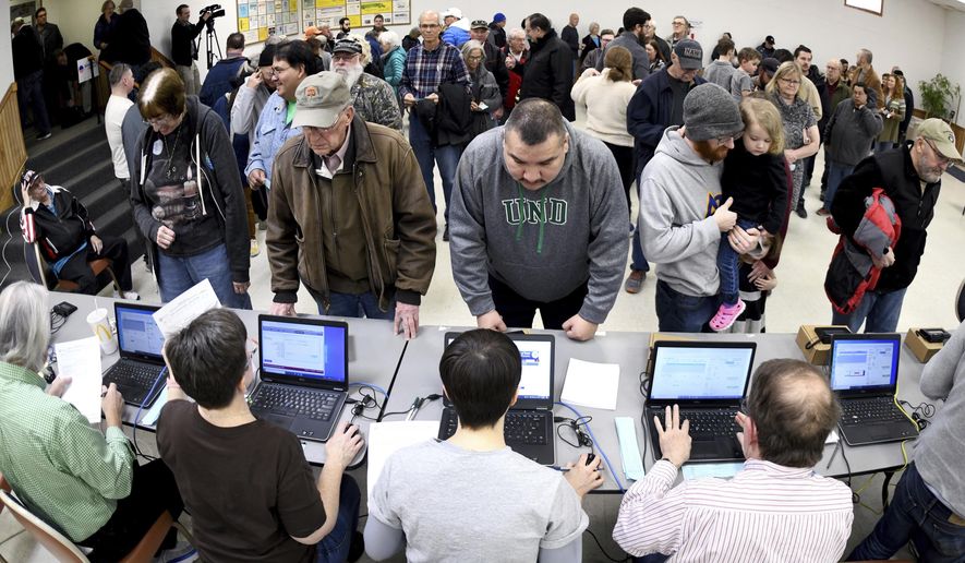 Caucus voters stand in line to register before voting at the North Dakota Democratic NPL Presidential Caucus inside the AFL-CIO House of Labor in Bismarck, N.D., Tuesday, March 10, 2020.  (Mike McCleary/The Bismarck Tribune via AP)