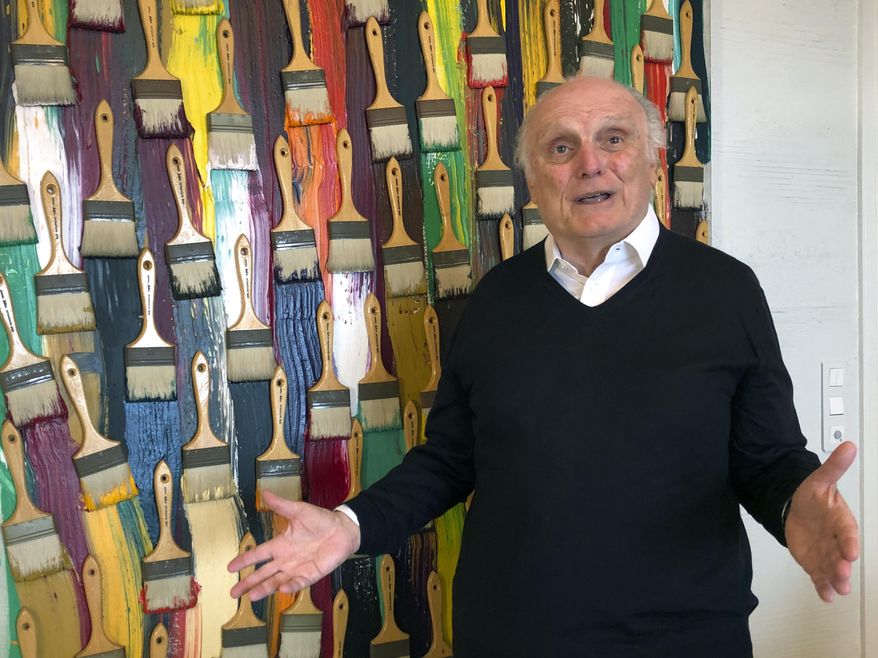 In this photo taken on Monday, March 2, 2020, billionaire art dealer David Nahmad poses in front of a colorful work by French-born American artist Arman, in Nahmad&#39;s home in Monaco. Nahmad has spent decades accumulating what he believes is now the world&#39;s largest private collection of works by Pablo Picasso, but he is about to part with one of them. A still life that Picasso painted in 1921 is being raffled off for charity in Paris this month with tickets at 100 euros each. (AP Photo/John Leicester)