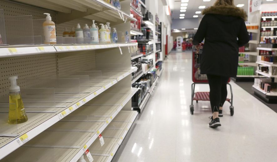 FILE - In this March 3, 2020 file photo, shelves that held hand sanitizer and hand soap are mostly empty at a Target in Jersey City, N.J.    People who may have been exposed to the new coronavirus or who get sick with COVID-19 may be advised to stay home for as long as 14 days to keep from spreading it to others, according to the Centers for Disease Control. That’s led many people to wonder if they could manage for two weeks at home without a run to the grocery store.   (AP Photo/Seth Wenig)