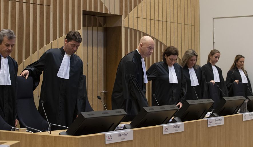 Presiding judge Hendrik Steenhuis, third from left, and other judges take their seats in court on the second day of the trial of four men charged with murder over the downing of Malaysia Airlines flight 17, at Schiphol airport, near Amsterdam, Netherlands, Tuesday, March 10, 2020. A missile fired from territory controlled by pro-Russian rebels in Ukraine in 2014, tore the MH17 passenger jet apart killing all 298 people on board. (AP Photo/Peter Dejong)