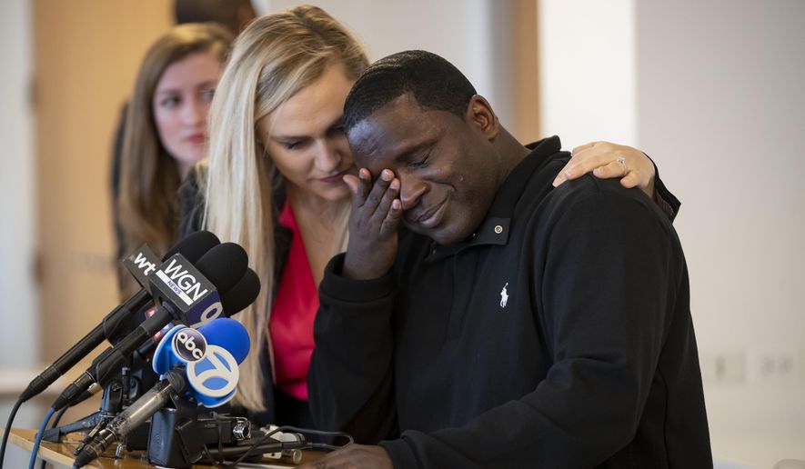 Anthony Gay becomes emotional while speaking March 10, 2020, about his years in solitary confinement, during a press conference Tuesday, March 10, 2020 in Chicago. Attorney Sarah Grady is consoling him. Gay went to prison in 1994 for stealing a dollar bill and a hat. Behavior problems, including self-mutilation, added to his sentence, and by the time he was released in August 2018, he had served 24 years in prison, 22 in solitary confinement. (Brian Cassella/Chicago Tribune via AP)