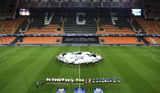 Atalanta and Valencia players line up ahead of the Champions League round of 16 second leg soccer match between Valencia and Atalanta in Valencia, Spain, Tuesday March 10, 2020. The match is being in an empty stadium because of the coronavirus outbreak. (UEFA via AP)