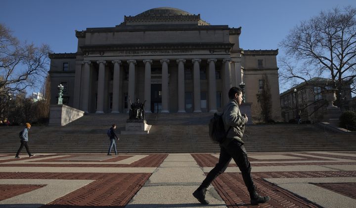 A man walks past Low Library on the Columbia University campus, Monday, March 9, 2020, in New York. (AP Photo/Mark Lennihan)