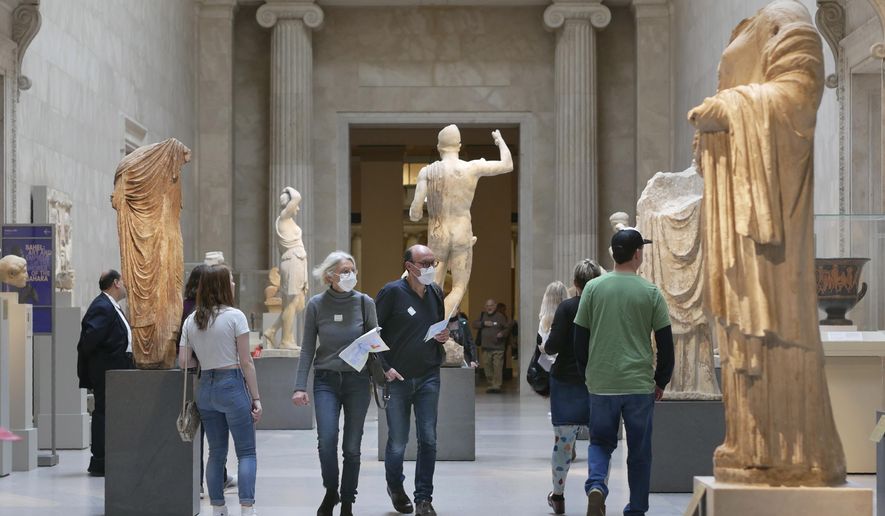 Two visitors wear masks as they walk through the Metropolitan Museum of Art in New York, Tuesday, March 10, 2020. (AP Photo/Seth Wenig) ** FILE **