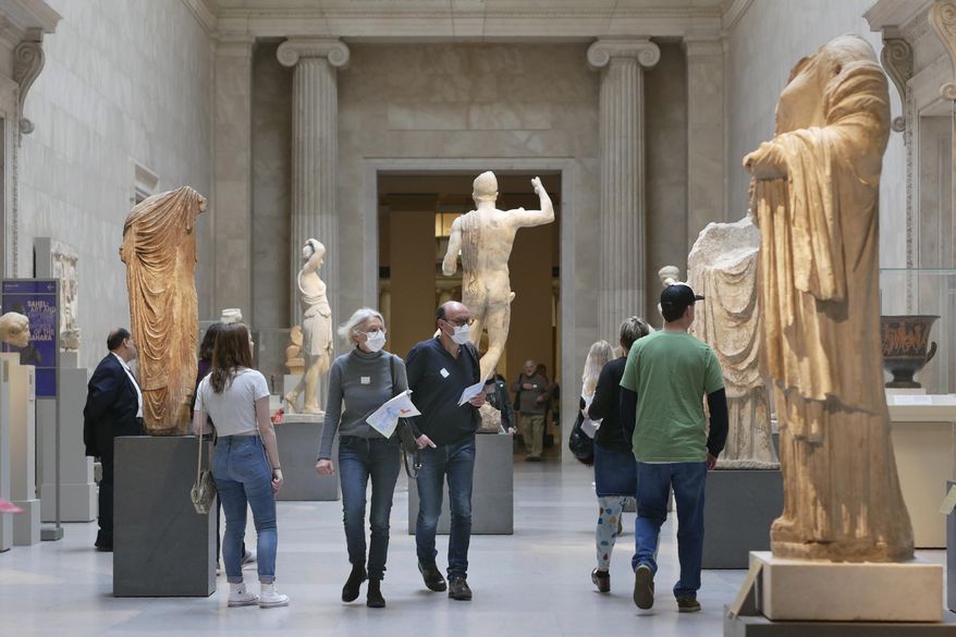 Two visitors wear masks as they walk through the Metropolitan Museum of Art in New York, Tuesday, March 10, 2020. (AP Photo/Seth Wenig) ** FILE **