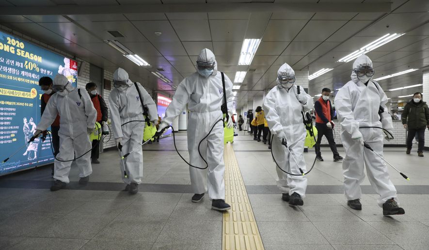 Workers wearing protective gears disinfect as a precaution against the new coronavirus at the subway station in Seoul, South Korea, Wednesday, March 11, 2020. (Kim Sun-woong/Newsis via AP)