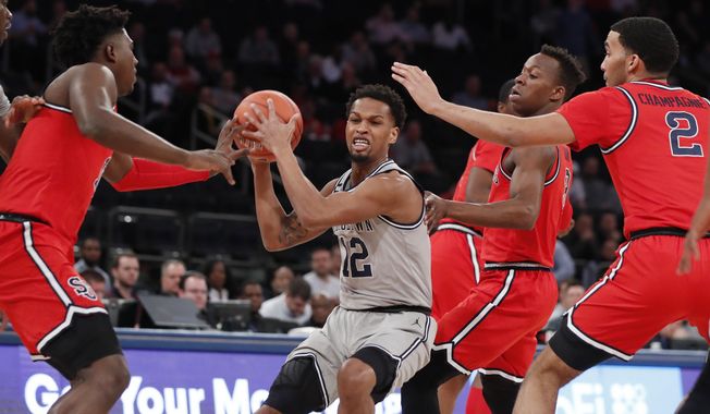 Georgetown guard Terrell Allen (12) is surrounded by St. John&#x27;s defenders during the first half of an NCAA college basketball game in the first round of the Big East men&#x27;s tournament Wednesday, March 11, 2020, in New York. (AP Photo/Kathy Willens)