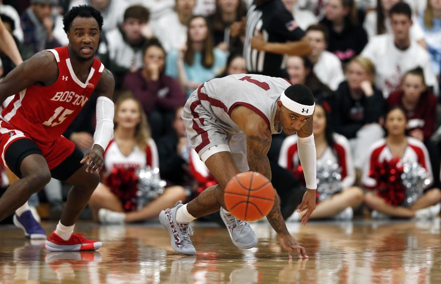Boston University&#x27;s Jonas Harper (15) and Colgate&#x27;s Jordan Burns (1) chase after the ball during the first half of the NCAA Patriot League Conference college basketball championship at Cotterell Court, Wednesday, March 11, 2020, in Hamilton, N.Y. (AP Photo/John Munson)