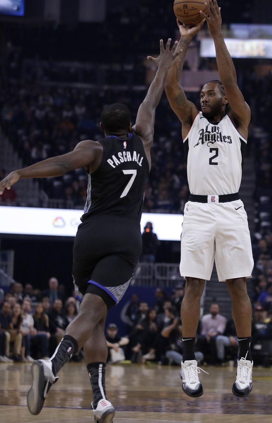 Los Angeles Clippers&#x27; Kawhi Leonard, right, shoots against Golden State Warriors&#x27; Eric Paschall (7) during the first half of an NBA basketball game Tuesday, March 10, 2020, in San Francisco. (AP Photo/Ben Margot)