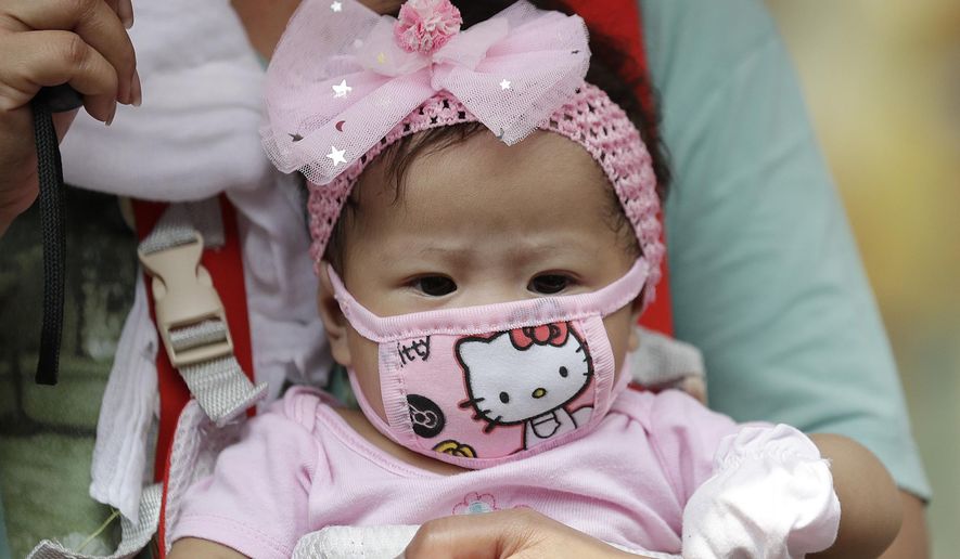 A baby wears a protective mask in Manila, Philippines on Wednesday, March 11, 2020. For most people, the new coronavirus causes only mild or moderate symptoms, such as fever and cough. For some, especially older adults and people with existing health problems, it can cause more severe illness, including pneumonia. (AP Photo/Aaron Favila)