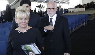 Televangelist Jim Bakker, right, walks with his wife Lori Beth Graham after a funeral service at the Billy Graham Library for the Rev. Billy Graham, who died last week at age 99, Friday, March 2, 2018, in Charlotte, N.C. (AP Photo/Chuck Burton) **FILE**