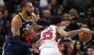 Utah Jazz center Rudy Gobert (27) guards Detroit Pistons forward Christian Wood (35) during the second half of an NBA basketball game Saturday, March 7, 2020, in Detroit. (AP Photo/Duane Burleson)