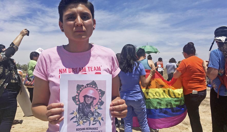 FILE - In this June 6, 2018, file photo, Gabriela Hernandez, executive director of the nonprofit New Mexico Dream Team, holds up an image in Albuquerque, N.M, of Roxsana Hernandez , a Honduran transgender woman who died while in U.S. custody. A transgender woman who has been detained with men in immigration custody for nine months says she's been sexually harassed and assaulted. Advocates say Alejandra Alor Reyes, an asylum-seeker from Mexico, is suffering from post-traumatic stress disorder and should be released on humanitarian grounds while she awaits an appeal to her asylum denial. They say transgender immigrants face unsafe conditions in detention and that none are being held with members of the gender they identify with. (AP Photo/Mary Hudetz, File)
