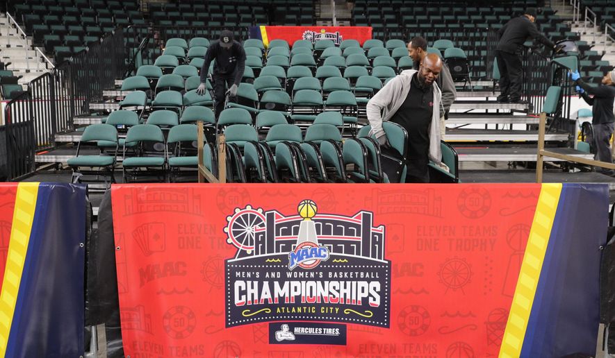 Workers dismantle seating after the men's and women's NCAA college basketball games at the Metro Atlantic Athletic Conference tournament were canceled, Thursday March 12, 2020, due to coronavirus concerns. (Edward Lea Staff/The Press of Atlantic City via AP)