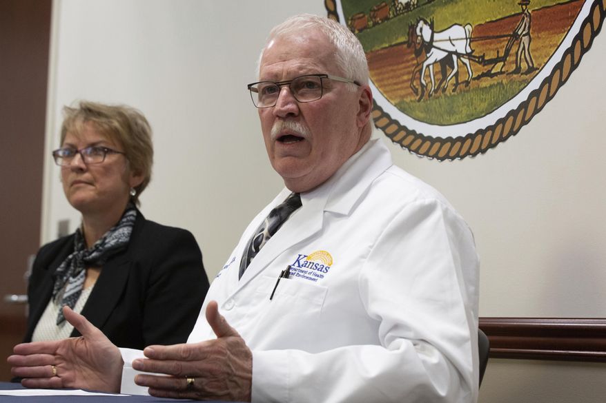 Lee Norman, Kansas Department of Health and Environment secretary, discusses with Mary Beverly, interim director of Johnson County's health agency, three confirmed cases of coronavirus that appeared in patients in Johnson County during a press conference Thursday, March 12, 2020 at KDHE headquarters in Topeka. (Evert Nelson/The Topeka Capital-Journal via AP)