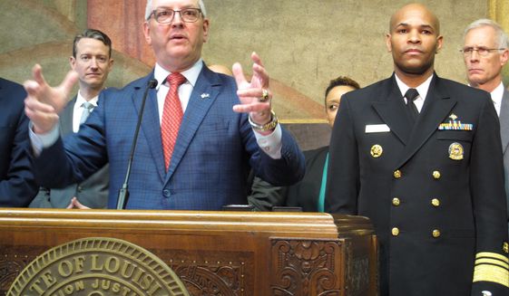 Louisiana Gov. John Bel Edwards speaks about the new coronavirus while U.S. Surgeon General Jerome Adams, right, listens on Thursday, March 12, 2020, in Baton Rouge, La. The number of cases of the COVID-19 disease caused by the virus are on the rise in Louisiana. (AP Photo/Melinda Deslatte)