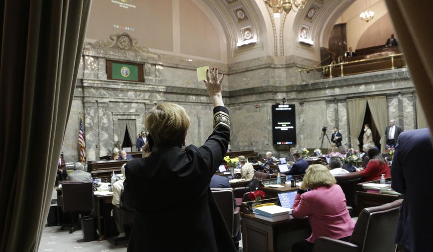Democratic Sen. Lisa Wellman raises her hand during a vote in the Washington Senate, Thursday, March 12, 2020 in Olympia, Wash. Lawmakers were finishing up their work amid concerns of the state's COVID-19 outbreak. For most people, the new coronavirus causes only mild or moderate symptoms. For some it can cause more severe illness. (AP Photo/Rachel La Corte)