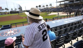 A woman wears a Derek Jeter as she settles into her seat prior to a spring training baseball game between the New York Yankees and the Washington Nationals, Thursday, March 12, 2020, in West Palm Beach, Fla. (AP Photo/Julio Cortez)