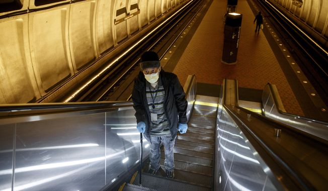 In this file photo, a Washington, D.C., man rides the escalator up at the Metro subway Congress Heights train station in Washington, Friday, March 13, 2020.  (AP Photo/Carolyn Kaster) ** FILE **