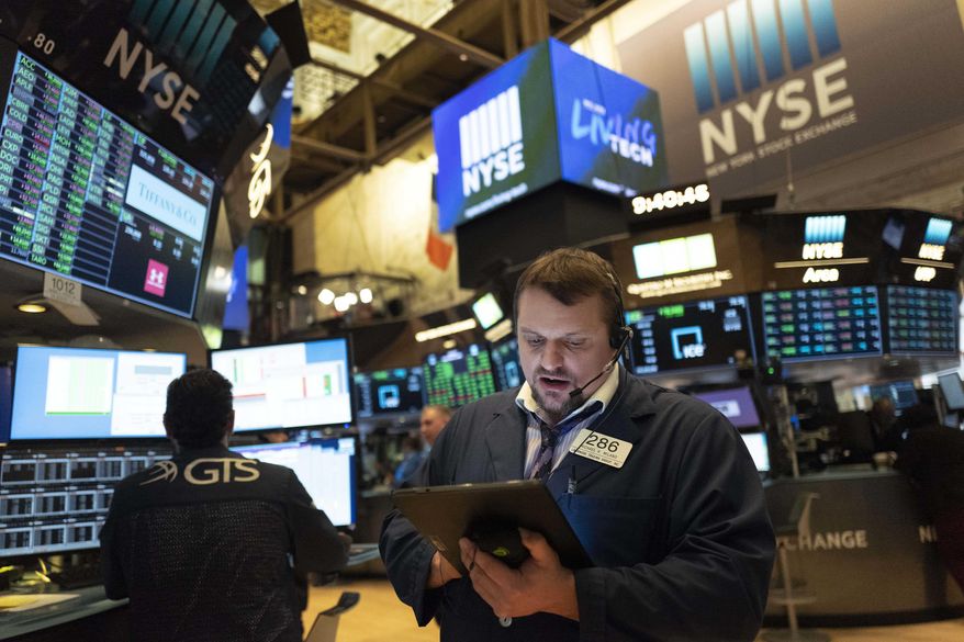 Stock trader Michael Milano works at the New York Stock Exchange, Friday, March 13, 2020. Stocks are opening sharply higher on Wall Street a day after the worst drop since 1987. (AP Photo/Mark Lennihan)