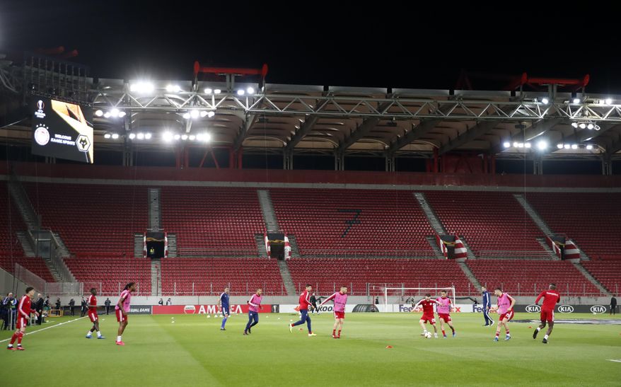 Olympiakos players challenge for the ball during warm up prior the Europa League round of 16 first leg soccer match between Olympiakos and Wolverhampton Wanderers at the Karaiskakis Stadium in Piraeus, Greece, Thursday, March 12, 2020. The match is being played in an empty stadium because of the coronavirus outbreak. (AP Photo/Thanassis Stavrakis)