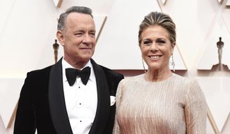 In this Sunday, Feb. 9, 2020 file photo, Tom Hanks, left, and Rita Wilson arrive at the Oscars at the Dolby Theatre in Los Angeles. (Photo by Jordan Strauss/Invision/AP)