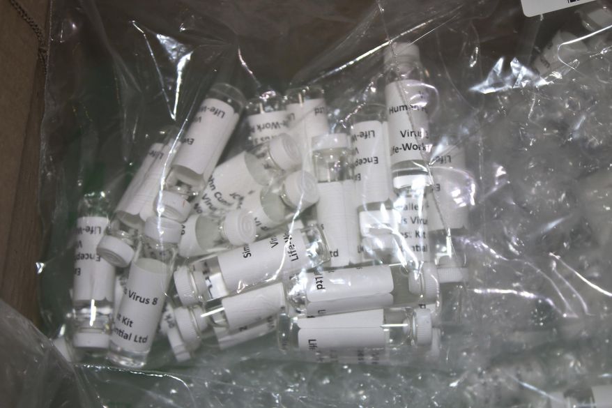 In this Thursday, March 12, 2020, photo released by the U.S. Customs and Border Protection (CBP), shows a package containing suspected counterfeit COVID-19 test kits arriving from the United Kingdom. CBP officers discovered six plastic bags containing various vials, while conducting an enforcement examination of a parcel manifested as "Purified Water Vials" with a declared value of $196.81. A complete examination of the shipment, led to the finding of vials filled with a white liquid and labeled "Corona Virus 2019nconv (COVID-19)" and "Virus1 Test Kit". The shipment was turned over to the U.S. Food and Drug Administration (FDA) for analysis. (U.S. Customs and Border Protection via AP)