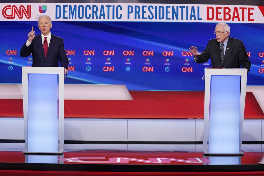 Former Vice President Joe Biden, left, and Sen. Bernie Sanders, I-Vt., right, participate in a Democratic presidential primary debate at CNN Studios in Washington, Sunday, March 15, 2020. (AP Photo/Evan Vucci)