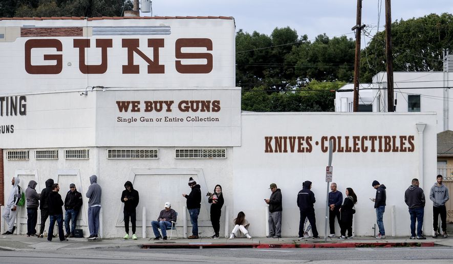 People wait in a line to enter a gun store in Culver City, Calif., Sunday, March 15, 2020. Coronavirus concerns have led to consumer panic buying of grocery staples and now gun stores are seeing a similar run on weapons and ammunition as panic intensifies. (AP Photo/Ringo H.W. Chiu)
