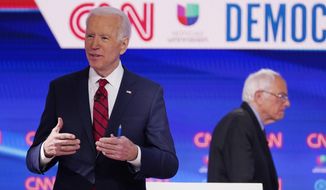 Sen. Bernie Sanders, I-Vt., right, and former Vice President Joe Biden, left, return to the stage after a commercial break in a Democratic presidential primary debate at CNN Studios, Sunday, March 15, 2020, in Washington. (AP Photo/Evan Vucci)