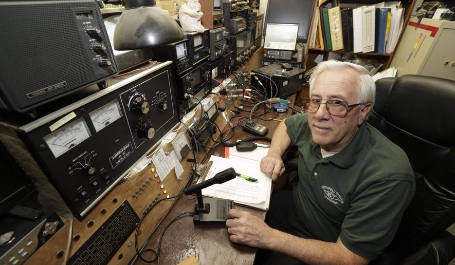 In this Friday, March 13, 2020 photo, Paul Buescher poses by his ham radio, in Northfield Center Township, Ohio. Buescher is one of 32 members of a group in northeastern Ohio that shares a farm packed with enough canned and dehydrated food and water to last for years. For those in the often-mocked "prepper" community, this is quickly becoming their "I told you so" moment, as panic buying has cleared store shelves across the U.S. amid growing fears that the new coronavirus will force many Americans to self-quarantine for weeks in their homes. (AP Photo/Tony Dejak)