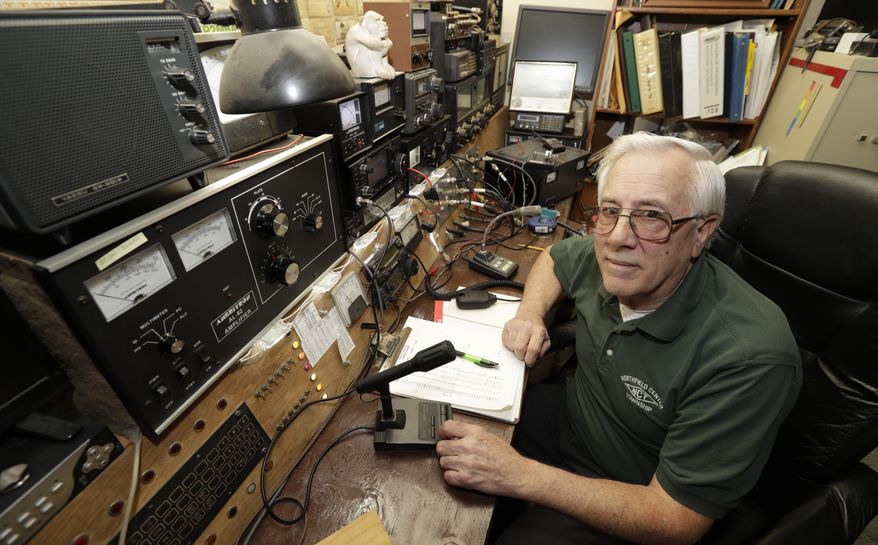 In this Friday, March 13, 2020 photo, Paul Buescher poses by his ham radio, in Northfield Center Township, Ohio. Buescher is one of 32 members of a group in northeastern Ohio that shares a farm packed with enough canned and dehydrated food and water to last for years. For those in the often-mocked "prepper" community, this is quickly becoming their "I told you so" moment, as panic buying has cleared store shelves across the U.S. amid growing fears that the new coronavirus will force many Americans to self-quarantine for weeks in their homes. (AP Photo/Tony Dejak)