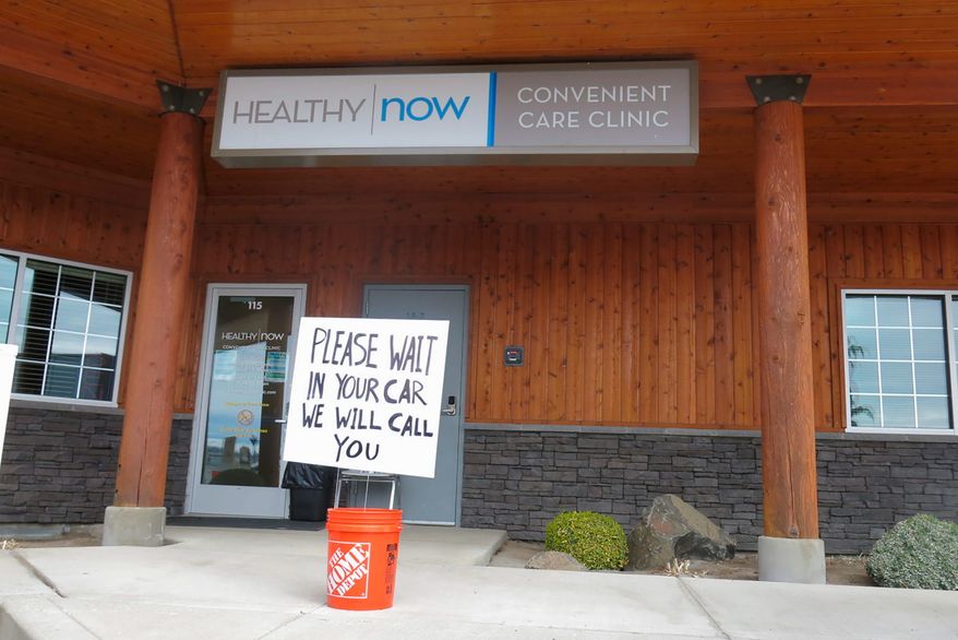 In a Sunday, March 15, 2020 photo, coronavirus patients at the Creekside HealthyNow clinic are asked to call or text the clinic when they arrive. A provider will then come to the car to triage the patient. (Janelle Retka/Yakima Herald-Republic via AP)