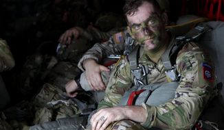 In this Jan. 26, 2020, photo, Sgt. Micah Jurekovic waits for takeoff inside a C-130 Hercules transport plane, with dozens of other 82nd Airborne Division paratroopers, to jump into Melgar, Colombia, alongside their South American counterparts during a training exercise. (AP photo/Sarah Blake Morgan)