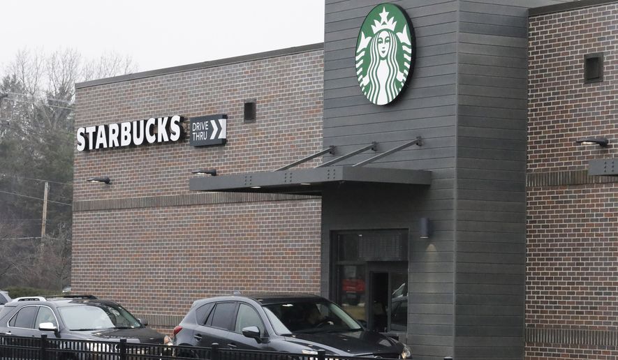 Customers wait for their order in their car at a Starbucks in Northbrook, Ill., Monday, March 16, 2020. (AP Photo/Nam Y. Huh)