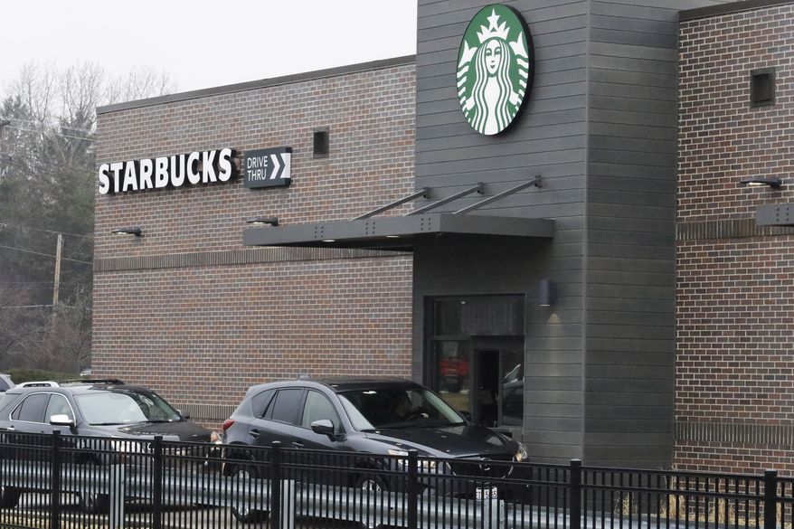 Customers wait for their order in their car at a Starbucks in Northbrook, Ill., Monday, March 16, 2020. (AP Photo/Nam Y. Huh)