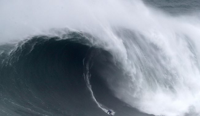 Kai Lenny from Hawaii rides a wave during the Nazare Tow Surfing Challenge at Praia do Norte or North Beach in Nazare, Portugal, Tuesday, Feb. 11, 2020. (AP Photo/Armando Franca)