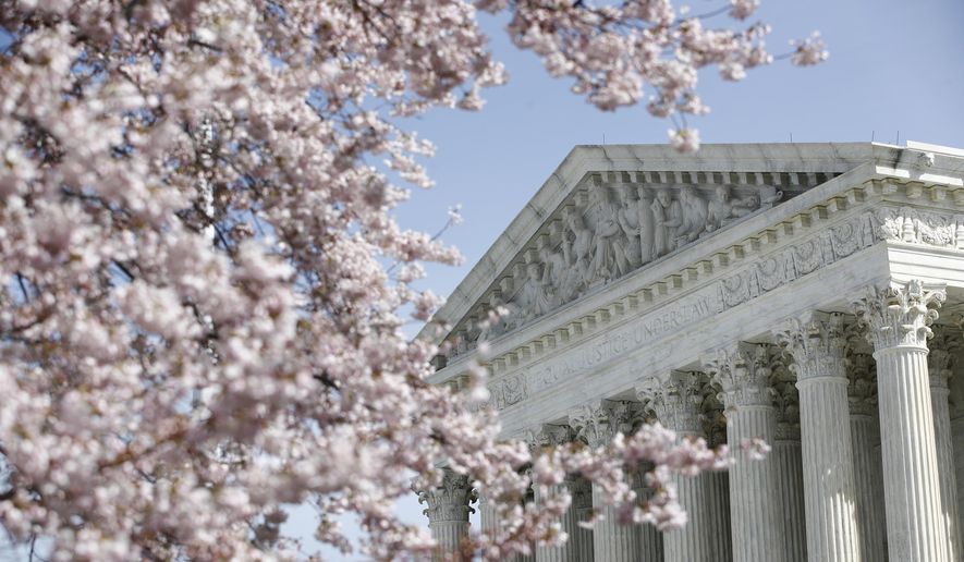 A tree blooms outside the Supreme Court in Washington, Monday, March 16, 2020. The Supreme Court announced Monday that it is postponing arguments for late March and early April because of the coronavirus, including fights over subpoenas for President Donald Trump's financial records. (AP Photo/Patrick Semansky)