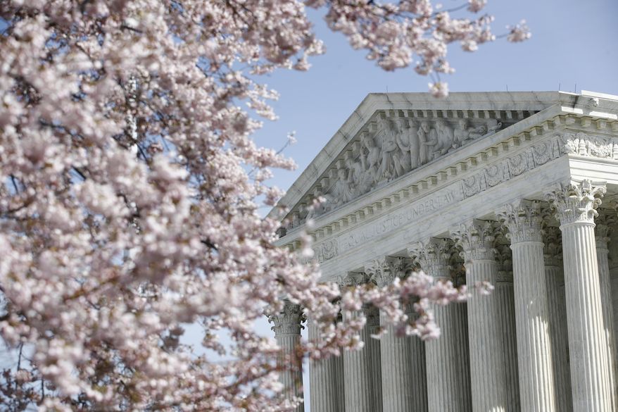 A tree blooms outside the Supreme Court in Washington, Monday, March 16, 2020. The Supreme Court announced Monday that it is postponing arguments for late March and early April because of the coronavirus, including fights over subpoenas for President Donald Trump's financial records. (AP Photo/Patrick Semansky)