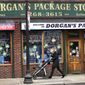 A woman pushes a stroller past a liquor store on a nearly empty sidewalk on Broadway on St. Patrick&#39;s Day in the South Boston neighborhood of Boston, Tuesday, March 17, 2020. For most people, the new coronavirus causes only mild or moderate symptoms. For some, it can cause more severe illness, especially in older adults and people with existing health problems. (AP Photo/Charles Krupa)